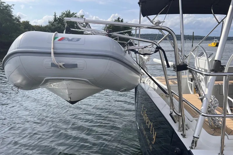 Slide: The Image of Sailboat Hanse 458 (2020) with dinghy on davits, docked by scenic waterfront. - 36