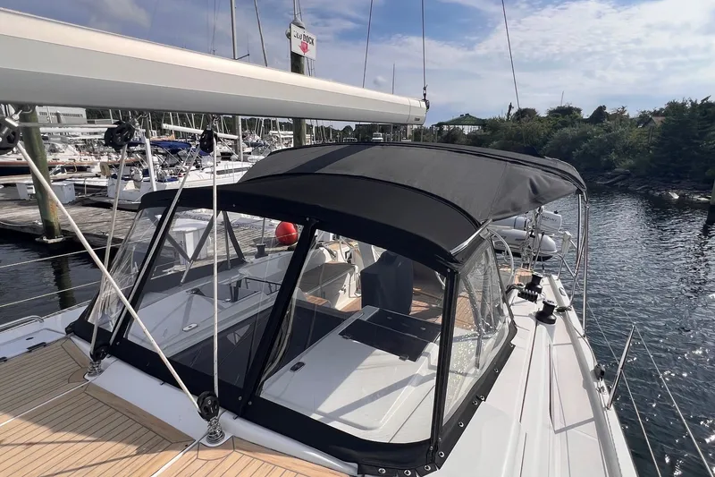 Slide: The Image of 2020 Hanse 458 yacht docked at marina with black canopy and clear windows. - 19