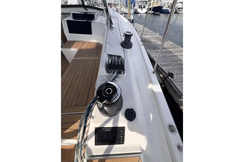 Slide: The Image of 2020 Hanse 458 yacht deck with winch, ropes, and control panel in marina setting. - 25