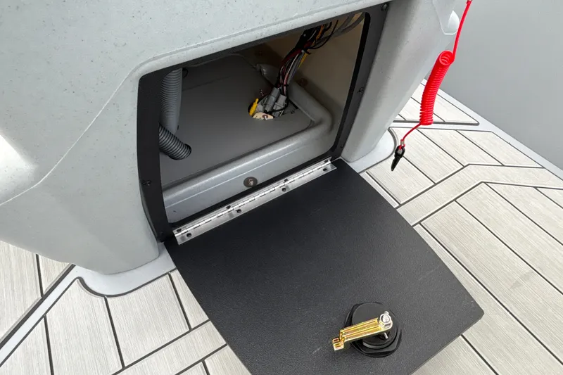 Slide: The Image of Open storage compartment of 2027 Tracker Bass Tracker Classic CC boat, showing wiring and safety features. - 18