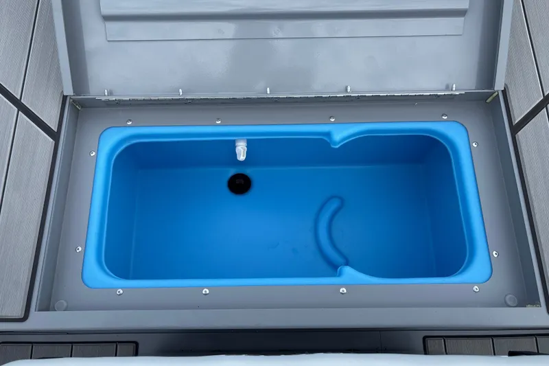 Slide: The Image of Livewell compartment in 2027 Tracker Bass Tracker Classic CC boat, featuring a blue interior. - 20