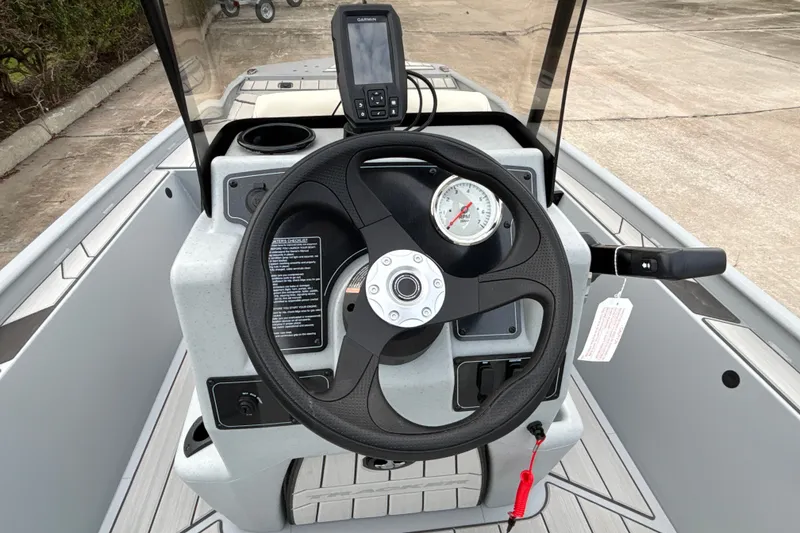Slide: The Image of 2027 Tracker Bass Tracker Classic CC dashboard with steering wheel and navigation display. - 13