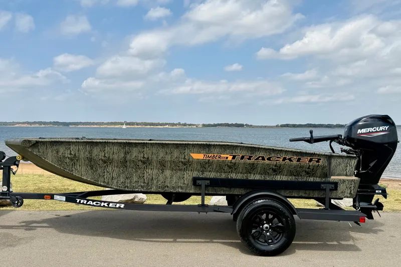 Slide: The Image of 2027 Tracker Grizzly 1553 Timber boat on trailer by a lake under a blue sky. - 14