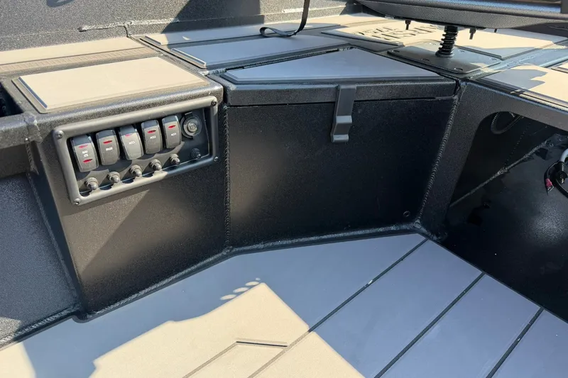 Slide: The Image of 2027 Tracker Grizzly 1756 T Marsh boat interior with control panel and storage compartment. - 16