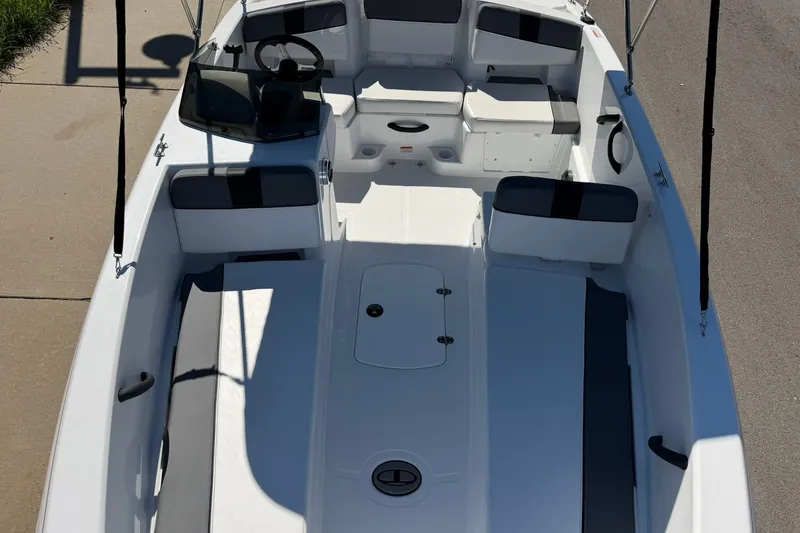Slide: The Image of 2027 Tahoe T18 boat interior with seating and steering wheel, docked on a sunny day. - 19