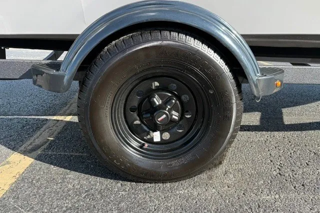 Slide: The Image of Trailer wheel of 2027 Tracker Super Guide V-16 T on asphalt surface. - 23