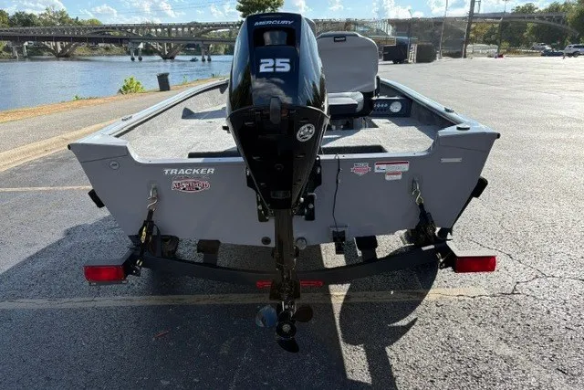 Slide: The Image of 2027 Tracker Super Guide V-16 T boat with Mercury 25 engine, parked near a river. - 12