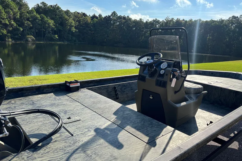 Slide: The Image of 2027 Tracker Grizzly 1860 CC boat by a serene lake with lush trees. - 68