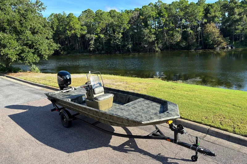 Slide: The Image of 2027 Tracker Grizzly 1860 CC boat on trailer by a scenic lake. - 67