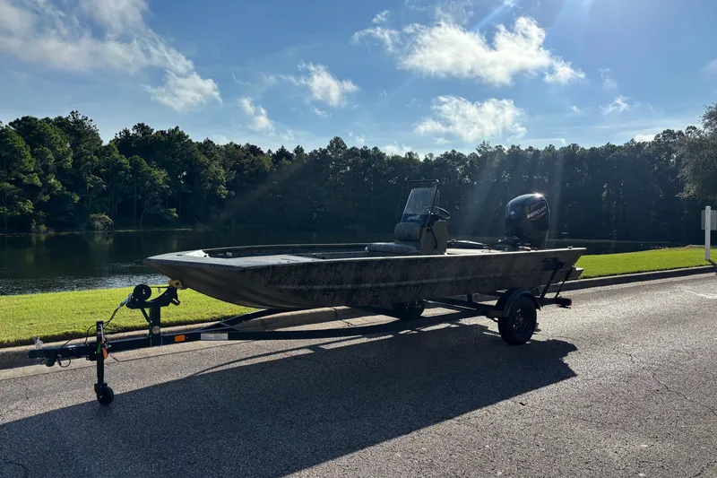 Slide: The Image of 2027 Tracker Grizzly 1860 CC boat on trailer by a scenic lake. - 63