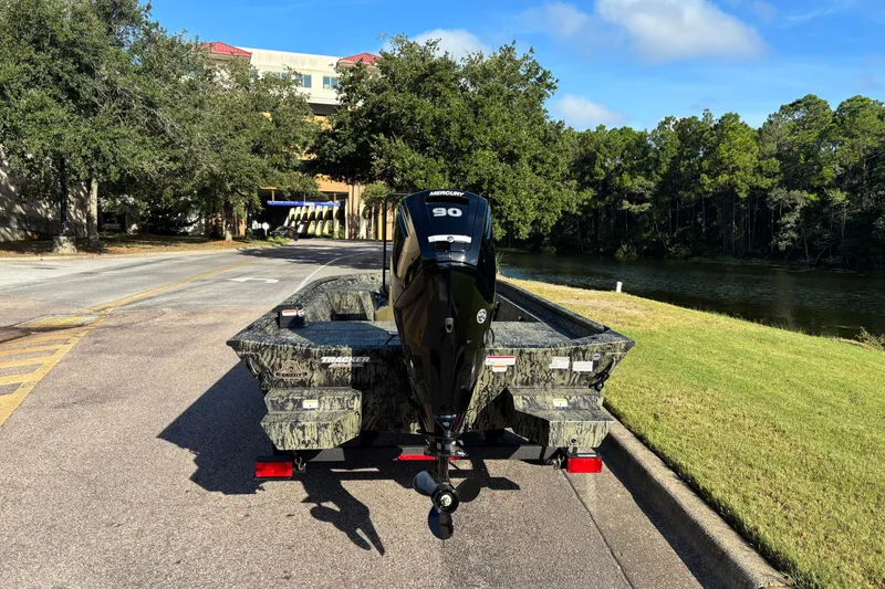 Slide: The Image of 2027 Tracker Grizzly 1860 CC boat on trailer near a scenic river. - 65