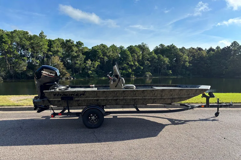 The Image of 2027 Tracker Grizzly 1860 CC boat on trailer by a scenic lake. - 0