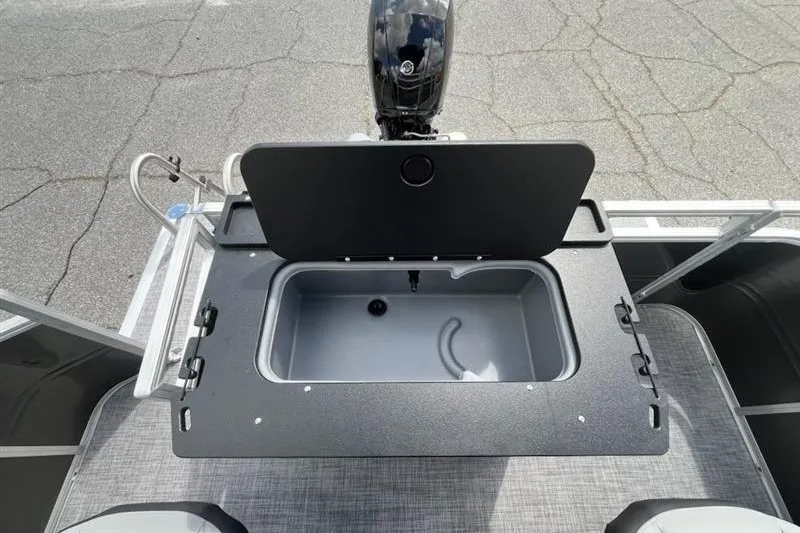 Slide: The Image of 2027 Sun Tracker SportFish 22 DLX boat with open storage compartment and motor. - 15