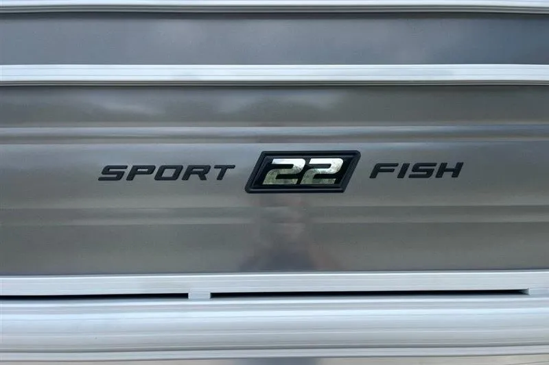 Slide: The Image of 2027 Sun Tracker SportFish 22 DLX boat logo on metallic surface. - 16