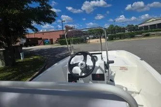 Slide: The Image of 2027 Mako Pro Skiff 17 CC boat parked outdoors under a clear blue sky. - 8