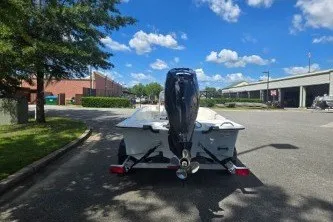 Slide: The Image of 2027 Mako Pro Skiff 17 CC boat on trailer, parked outdoors under a clear blue sky. - 7