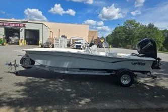 Slide: The Image of 2027 Mako Pro Skiff 17 CC boat on trailer, parked outdoors under blue sky. - 3