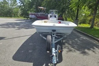 Slide: The Image of 2027 Mako Pro Skiff 17 CC boat on trailer in sunny parking lot. - 2