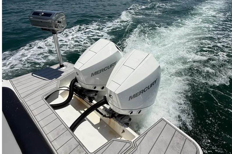 Slide: The Image of Twin Mercury outboard engines on a 2021 Schaefer 303 boat, cruising on open water. - 19