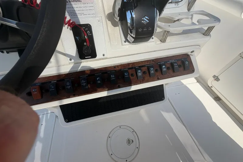 Slide: The Image of Center console controls of a 2001 Century 2900 boat, featuring switches and steering wheel. - 21
