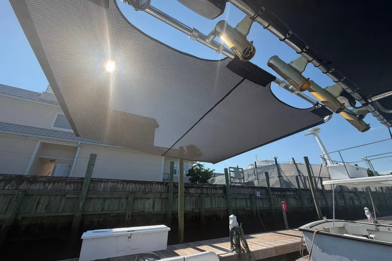 Slide: The Image of Sunshade on a 2001 Century 2900 Center Console boat docked near a wooden fence. - 41