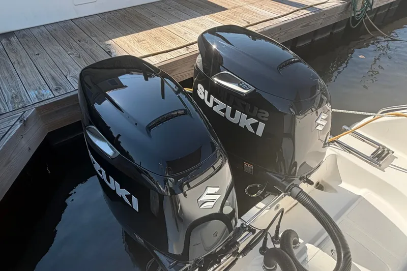 Slide: The Image of Twin Suzuki outboard motors on a 2001 Century 2900 Center Console boat at dock. - 35