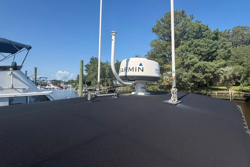 Slide: The Image of 2001 Century 2900 Center Console with Garmin radar, docked near lush greenery. - 54