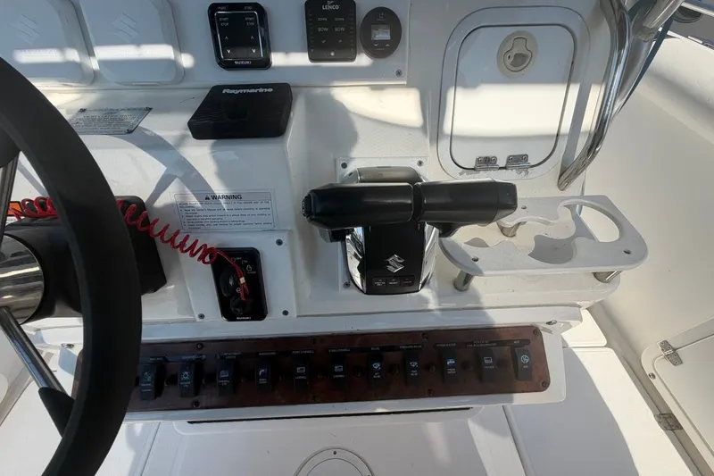 Slide: The Image of Center console controls of a 2001 Century 2900 boat with steering wheel and switches. - 23