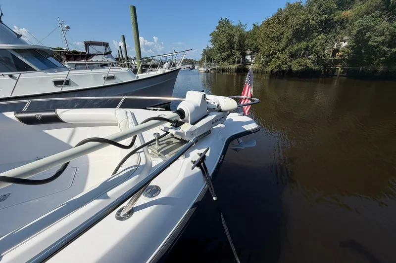 Slide: The Image of 2001 Century 2900 Center Console boat docked on a calm river with American flag. - 6
