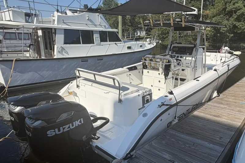 Slide: The Image of 2001 Century 2900 Center Console boat with dual Suzuki engines docked at marina. - 2