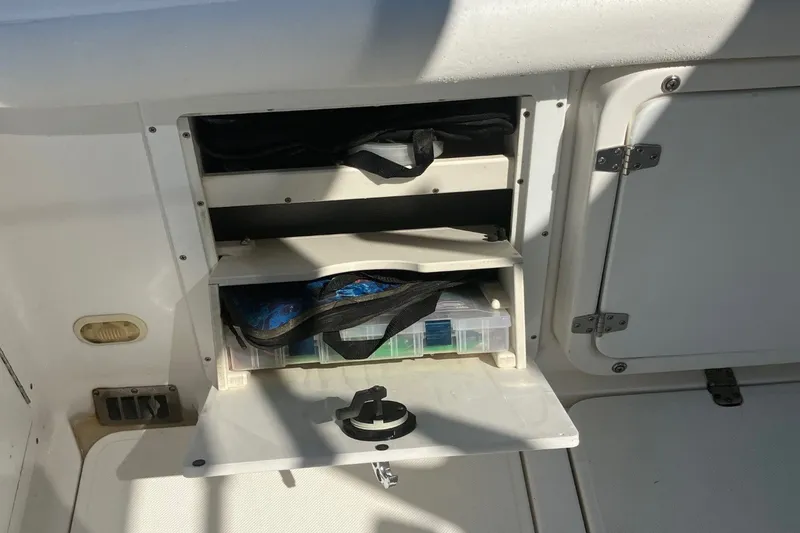 Slide: The Image of Storage compartment on a 2001 Century 2900 Center Console boat, featuring organized shelves and gear. - 63