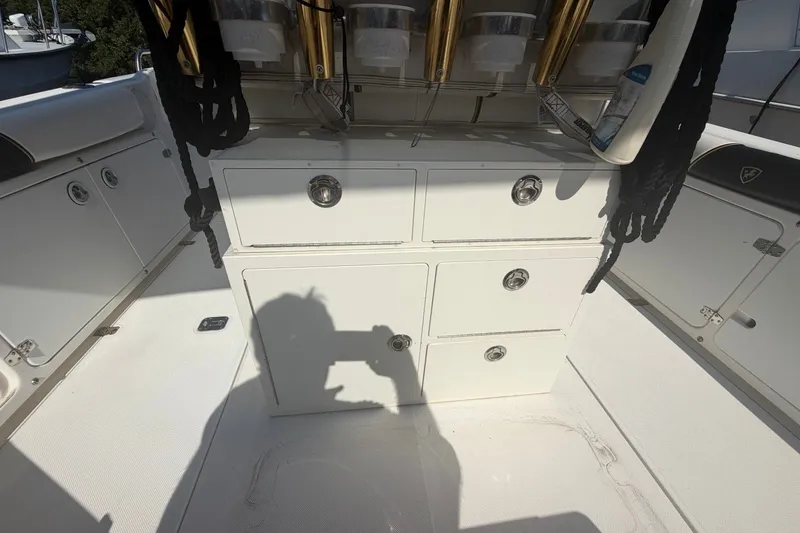 Slide: The Image of 2001 Century 2900 Center Console boat interior with storage compartments and fishing rod holders. - 25