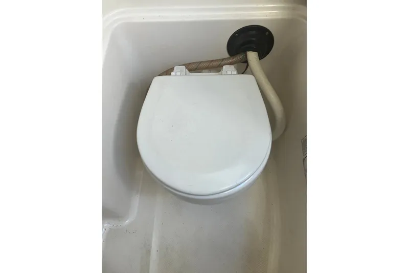 Slide: The Image of Boat toilet in 2001 Century 2900 Center Console, white seat with attached hose. - 65