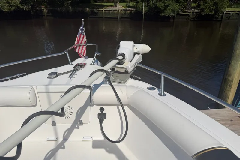 Slide: The Image of 2001 Century 2900 Center Console boat with American flag and trolling motor on calm water. - 9