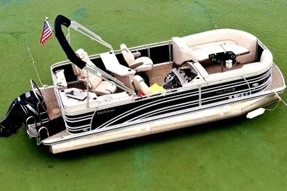 The Image of 2018 Harris Solstice 220 pontoon boat on green water, featuring comfortable seating and American flag. - 1
