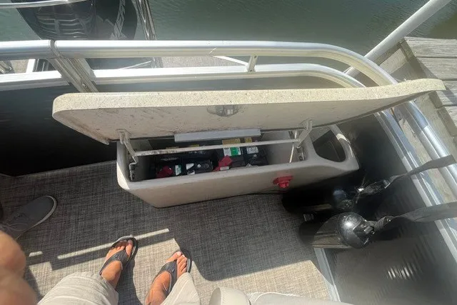 Slide: The Image of Open storage compartment on a 2018 Harris Solstice 220 boat, showing various items inside. - 22