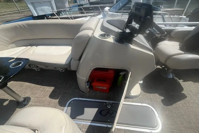 Slide: The Image of 2018 Harris Solstice 220 boat interior with seating, storage, and control panel. - 20