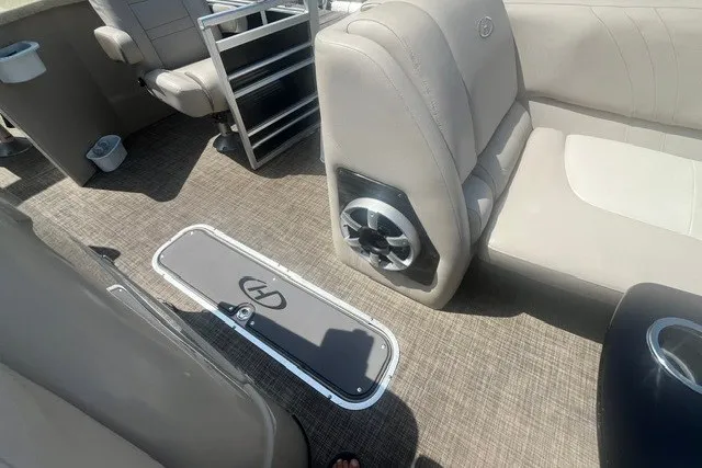 Slide: The Image of 2018 Harris Solstice 220 boat interior with beige seating and carpeted flooring. - 18