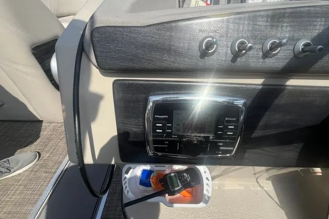 Slide: The Image of Control panel of a 2018 Harris Solstice 220 boat with radio and switches. - 16