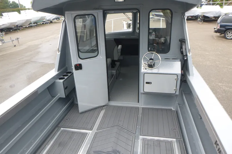Slide: The Image of 2027 KingFisher 2825 Coastal Express boat interior with steering wheel and seating area. - 5
