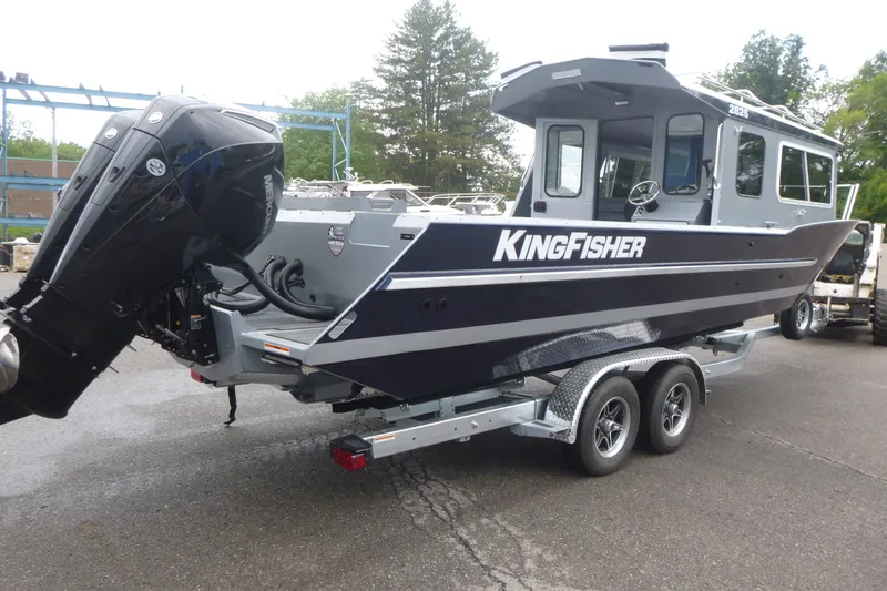 Slide: The Image of 2027 KingFisher 2825 Coastal Express boat on trailer, featuring sleek design and powerful outboard motor. - 2
