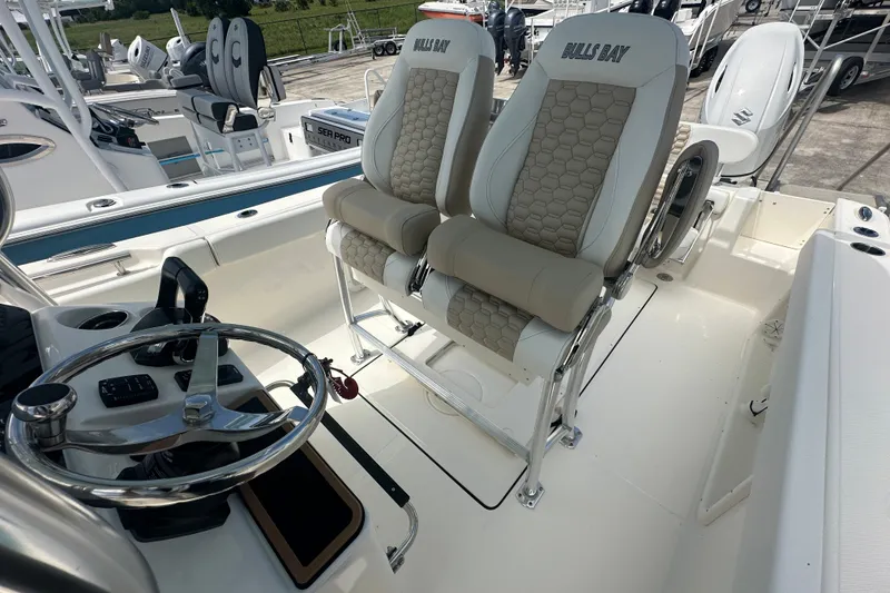 Slide: The Image of 2027 Bulls Bay 255 Center Console boat interior with dual seats and steering wheel. - 7