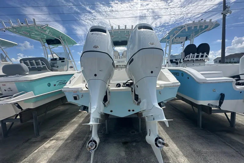 Slide: The Image of 2027 Bulls Bay 255 Center Console boat with dual outboard motors, docked under a clear sky. - 3