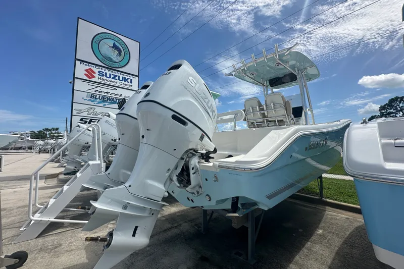 Slide: The Image of 2027 Bulls Bay 255 Center Console boat with Suzuki outboard motor at dealership. - 2