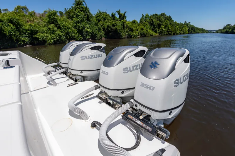 Slide: The Image of Three Suzuki 350 HP outboard engines are mounted on the stern of a boat on a calm river. - 18