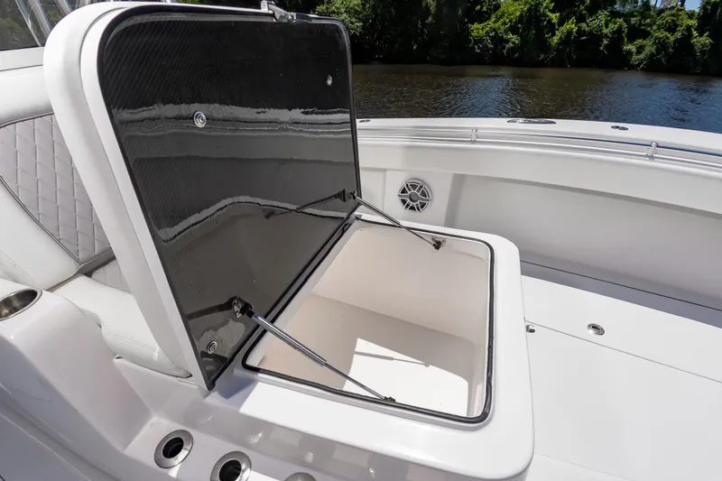 Slide: The Image of An open storage compartment on a SeaHunter 38 CTS boat, surrounded by white upholstery. - 33