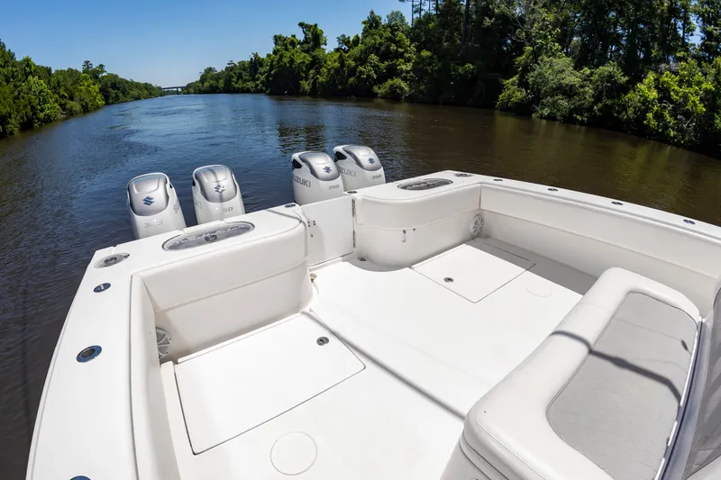 Slide: The Image of A 2022 SeaHunter 38 CTS on a calm river, surrounded by lush greenery. - 16