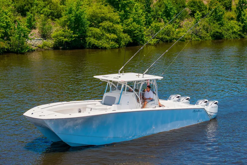 Slide: The Image of A white 2022 SeaHunter 38 CTS boat cruises on a calm river, surrounded by green trees. - 41