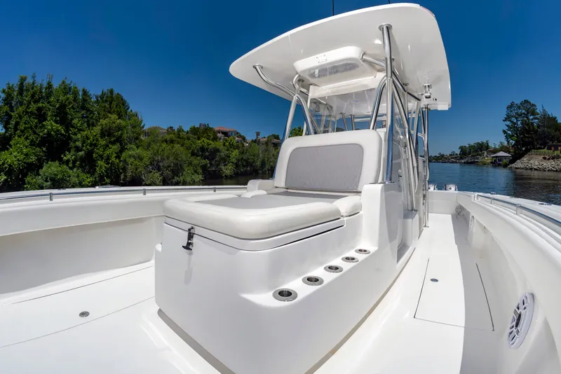 Slide: The Image of A sleek, modern boat with white upholstery and a T-top, on a calm river. - 29