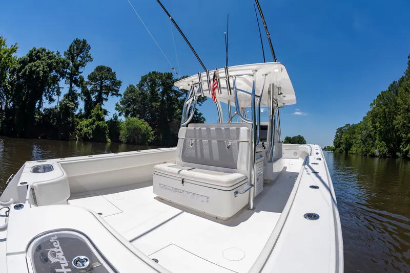 Slide: The Image of A 2022 SeaHunter 38 CTS boat on a calm river, surrounded by trees. - 14